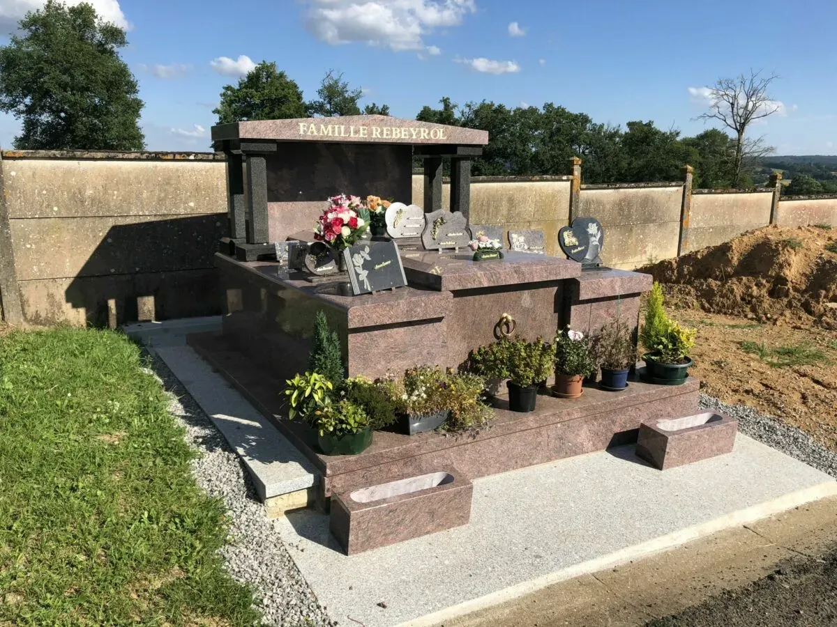 Caveau funéraire familial en granit de la famille Rebeyrol orné de fleurs.